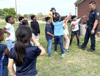 officers throw football with kids