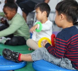 Children listening to story while playing with sensory toys