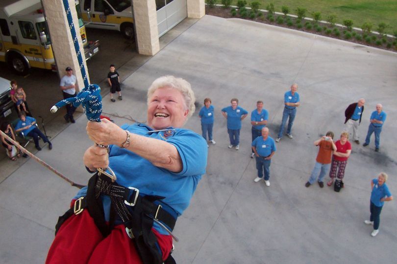 Former Councilmember Nancy Welton belaying down tower smiling during the Citizens Fire Academy