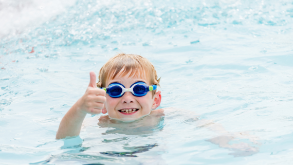 boy swimming and giving a thumbs up