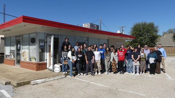 Students standing in front of vacant donut shop