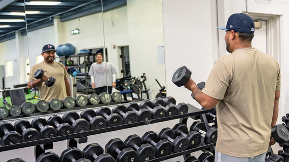 Photo of a man lifting weights at the Hurst Recreation Center