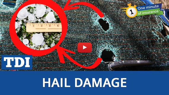 Image with car windshield shattered by hail and ruler measuring size of hail