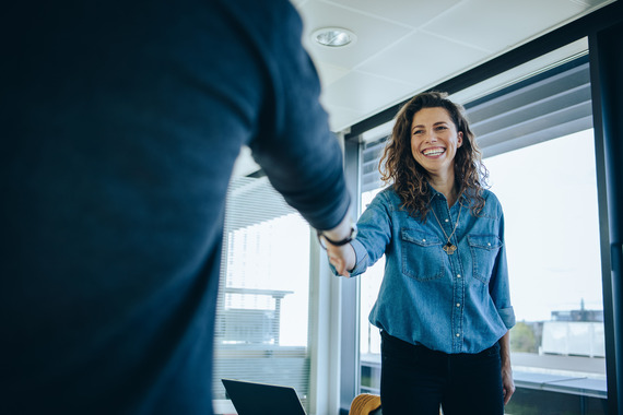 A professional man and woman shaking hands in an office