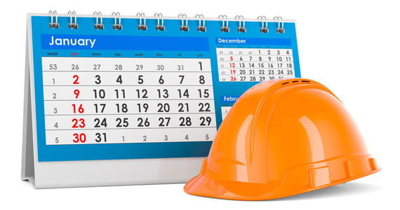 A hard hat sets beside an calendar.