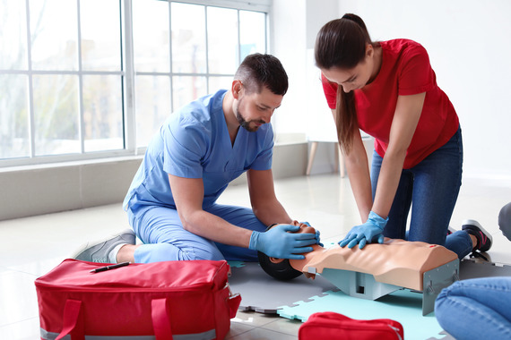 Two people performing CPR on a training model.