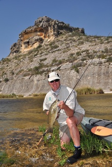 Man river fishing with kayak nearby