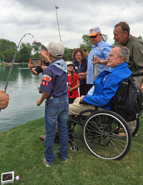 young boy scout with President George H.W. Bush fishing near pond