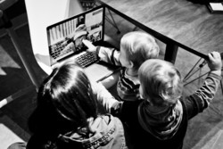 Small children around a computer skyping to their grandfather. 