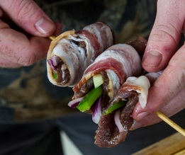 bacon-wrapped dove kebab being pushed onto skewer