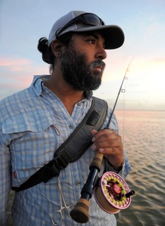 man on saltwater holding fly fishing rod 