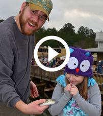 smiling man and his daughter with rainbow trout, video link