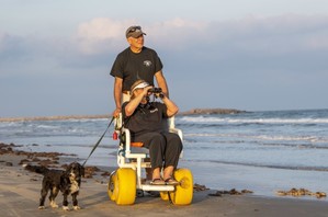 Woman on beach in wheelchair rented at Mustang Island SP
