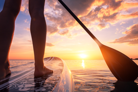SUP in water at sunset