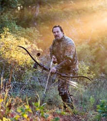 standing bowhunter, backlit 