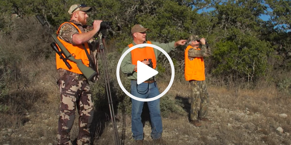 Three men, all wearing blaze orange hunting vests, looking for game.