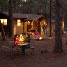 A family decorating a cabin with holiday lights