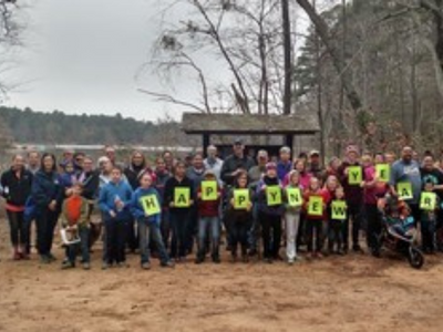 A group of hikers holding signs that read happy new year