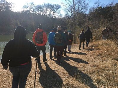 A group of people hiking along the edge of water