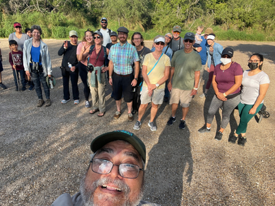 A park guide taking a group selfie of hikers