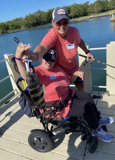 Special Needs event picture of a woman in a wheelchair catching a fish