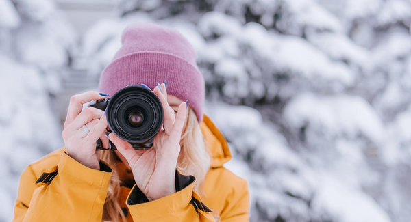 Female photographer in winter with pink hat