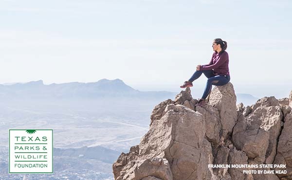 Image of a woman sitting on top of a mountain