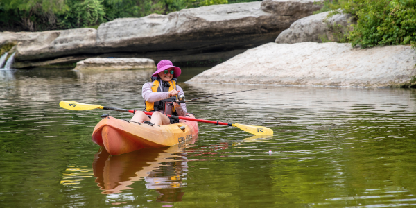 Image of a woman fishing from a kayak.