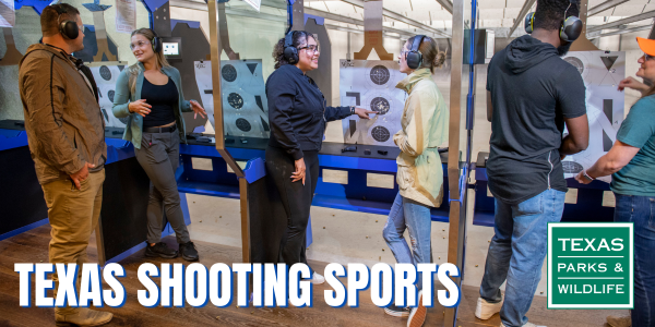 A group of people at an indoor gun range.