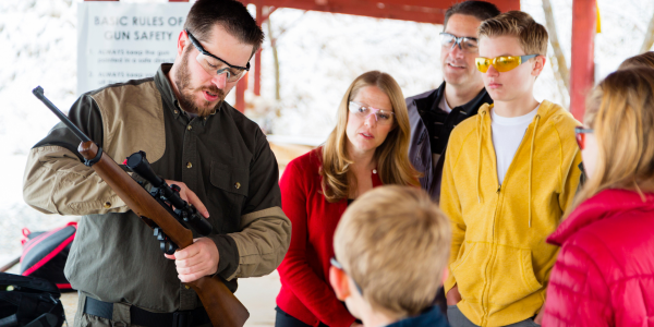 Image of an instructor at a gun range talking to a group of people.