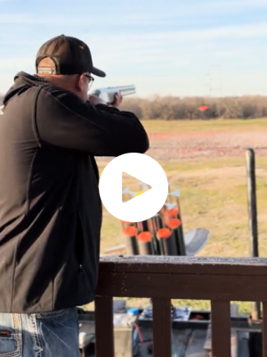 Scott Robertson aiming a shotgun at a sporting clay.