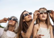 3 generations of women in eclipse glasses