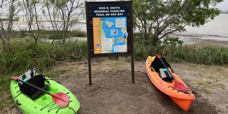 Ron Smith Memorial Paddling Trail on Oso Bay sign with kayaks, link