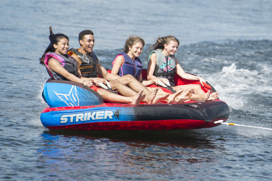 kids being towed on a tube behind a boat