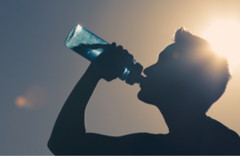 Silhouette of man drinking water in sun