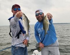 Picture of two men holding fish they caught