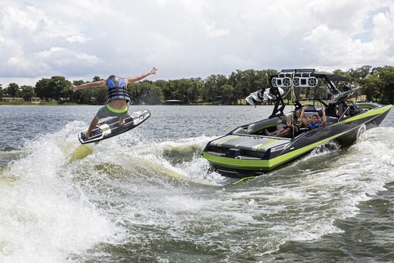 Wake surfer jumping behind a boat