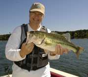 Female TPWD employee holds bass up