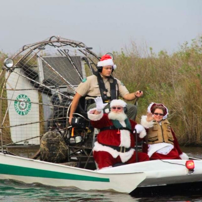 Santa and Mrs. Claus on an airboat.