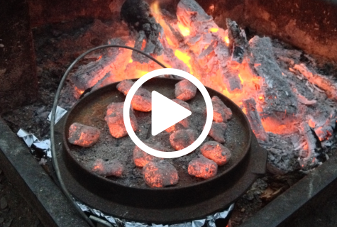 Dutch oven covered in hot coals