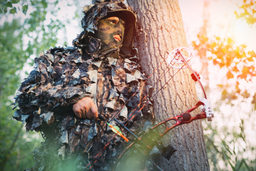 bowhunter by tree