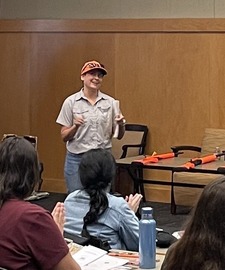 Female instructor teaching in classroom wearing hunting gear
