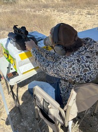 Student shooting hunting pistol at range