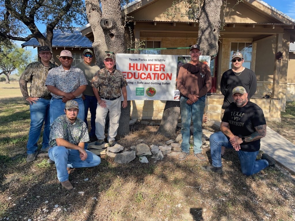 Hunters posing in front of Hunter Ed sign