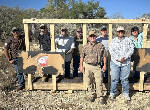 Class at the range posing with targets
