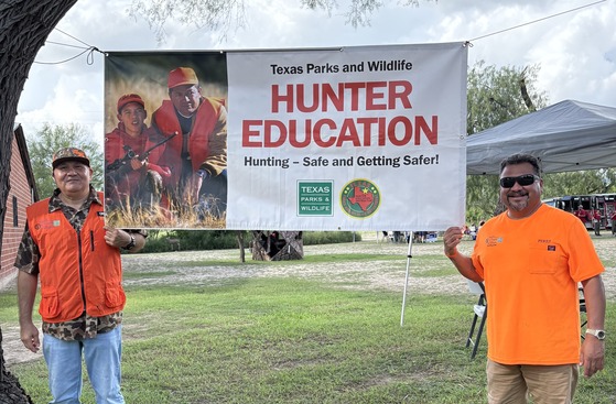 Instructors posing with Hunter Ed sign