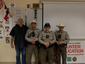 Instructor posing with Game Wardens in classroom