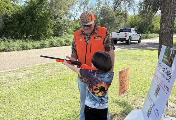 Instructor helping student safely aim an inert training gun