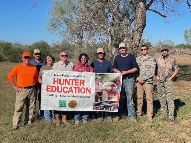 Class picture of a hunting class holding class banner