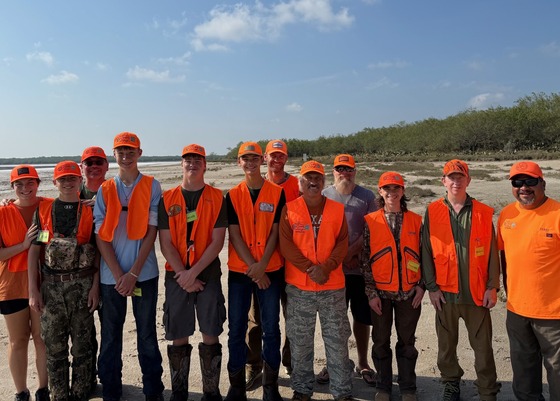 Hunters pose in front of salt lake bed